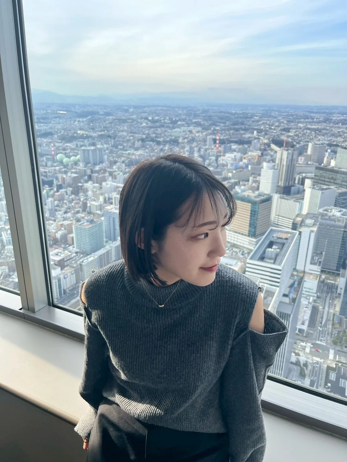 窓辺で街を眺めるAncoreのメンバー